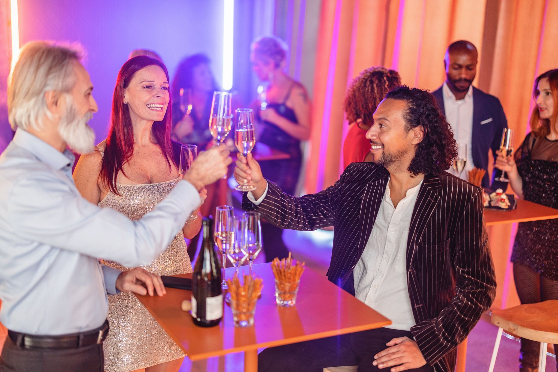 A group of people are toasting with champagne glasses at a party.