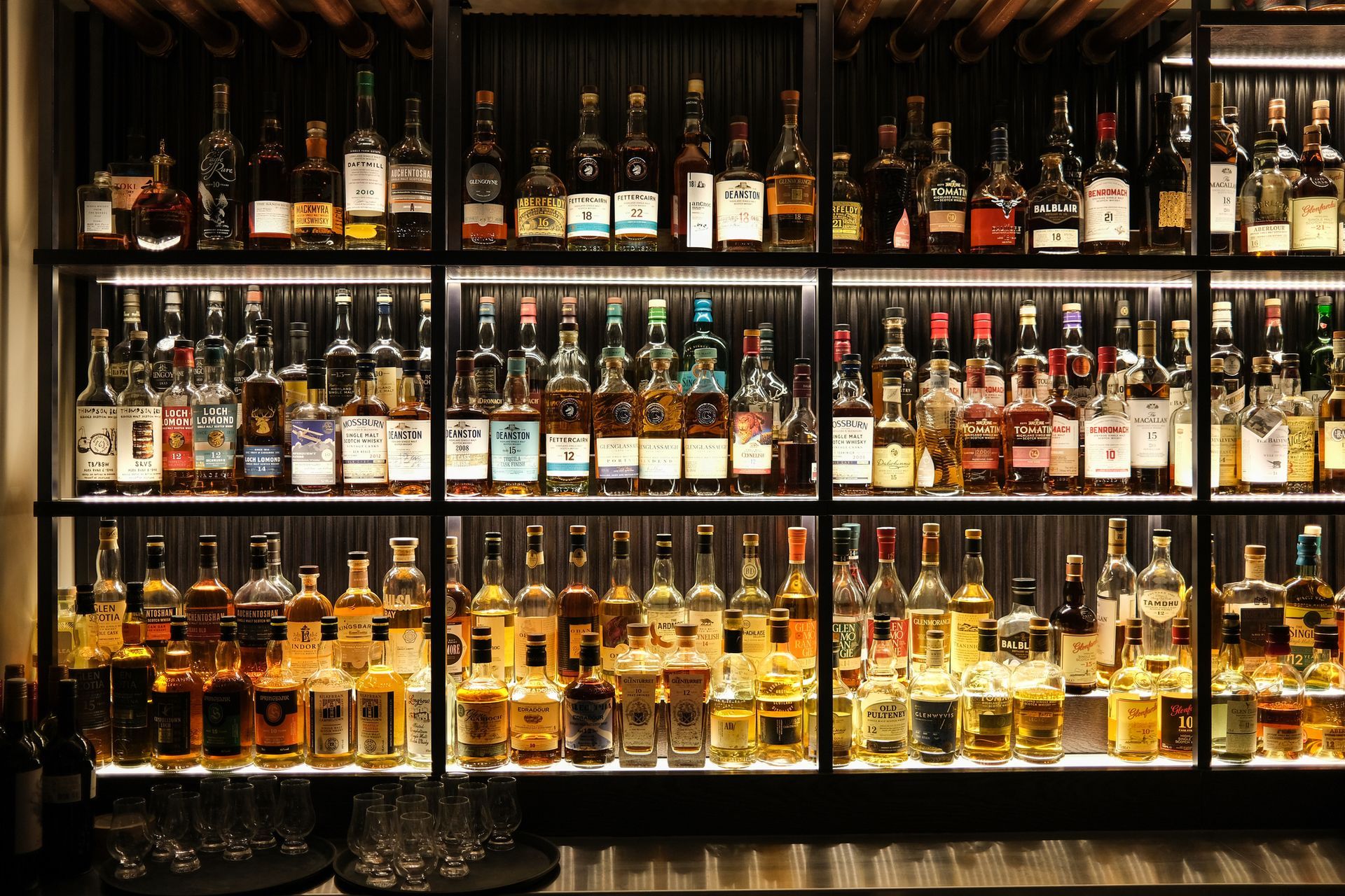 A store shelf filled with lots of bottles of alcohol
