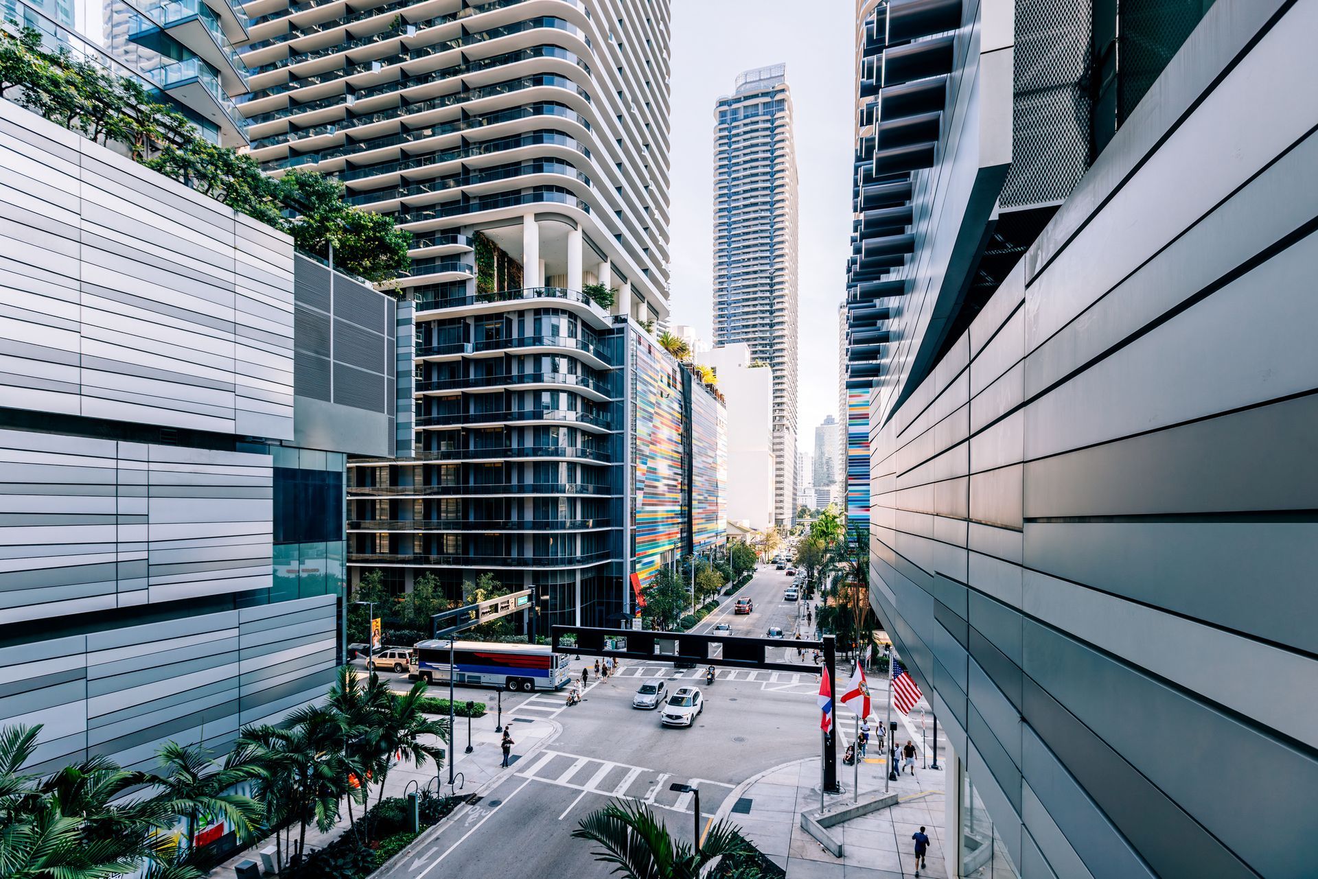 A city street with a lot of tall buildings and cars driving down it.