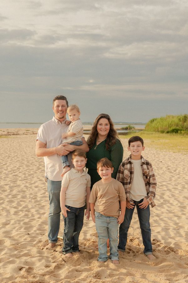 A family is posing for a picture in the woods.