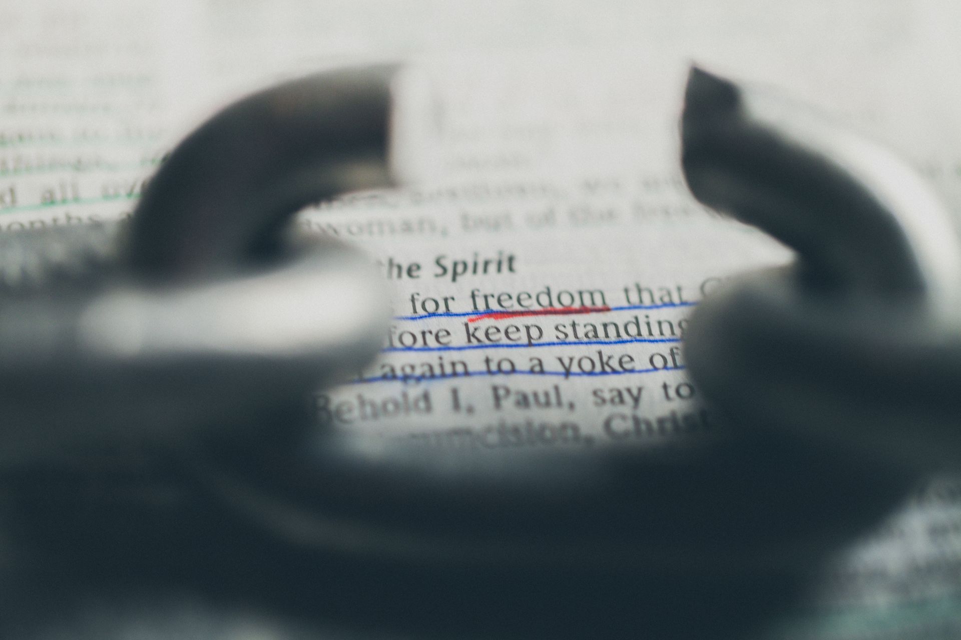 A close up of a broken chain on top of a bible.