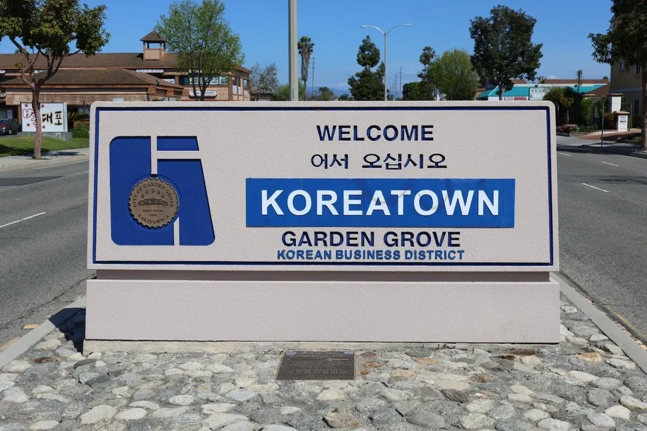 Welcome sign for Koreatown, Garden Grove, in English and Korean, with a blue and beige design.