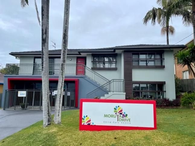 A Large White Building With A Red Door And Stairs And A Sign That Says Mobilize Drive — Moruya Drive Child Care Centre In Port Macquarie, NSW