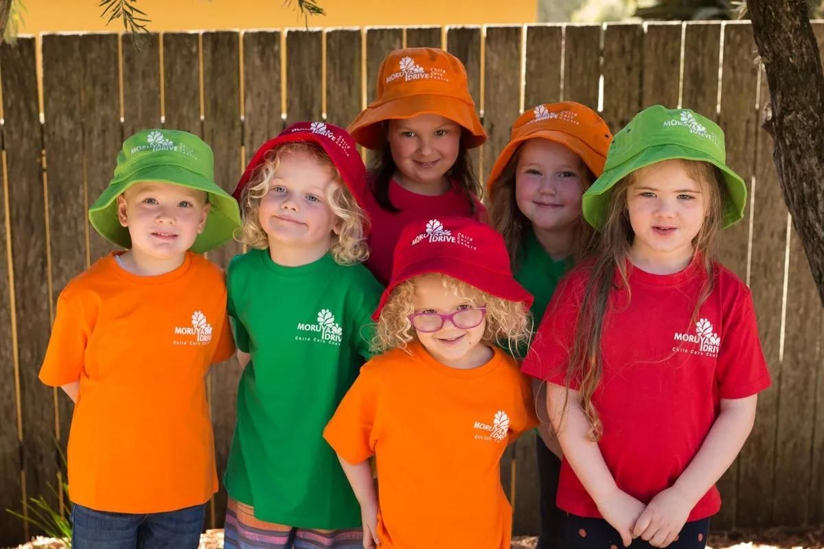 A Group Of Young Girls Wearing Hats And Shirts Are Posing For A Picture — Moruya Drive Child Care Centre In Port Macquarie, NSW