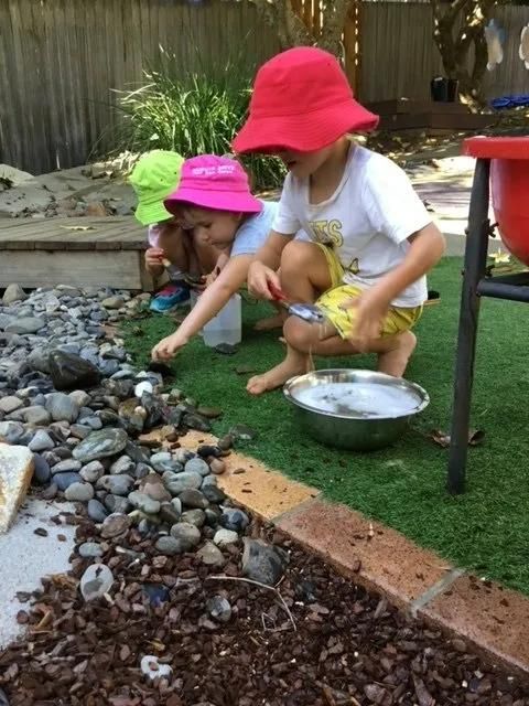 Two Children Are Playing With Rocks And A Bowl Of Water — Moruya Drive Child Care Centre In Port Macquarie, NSW