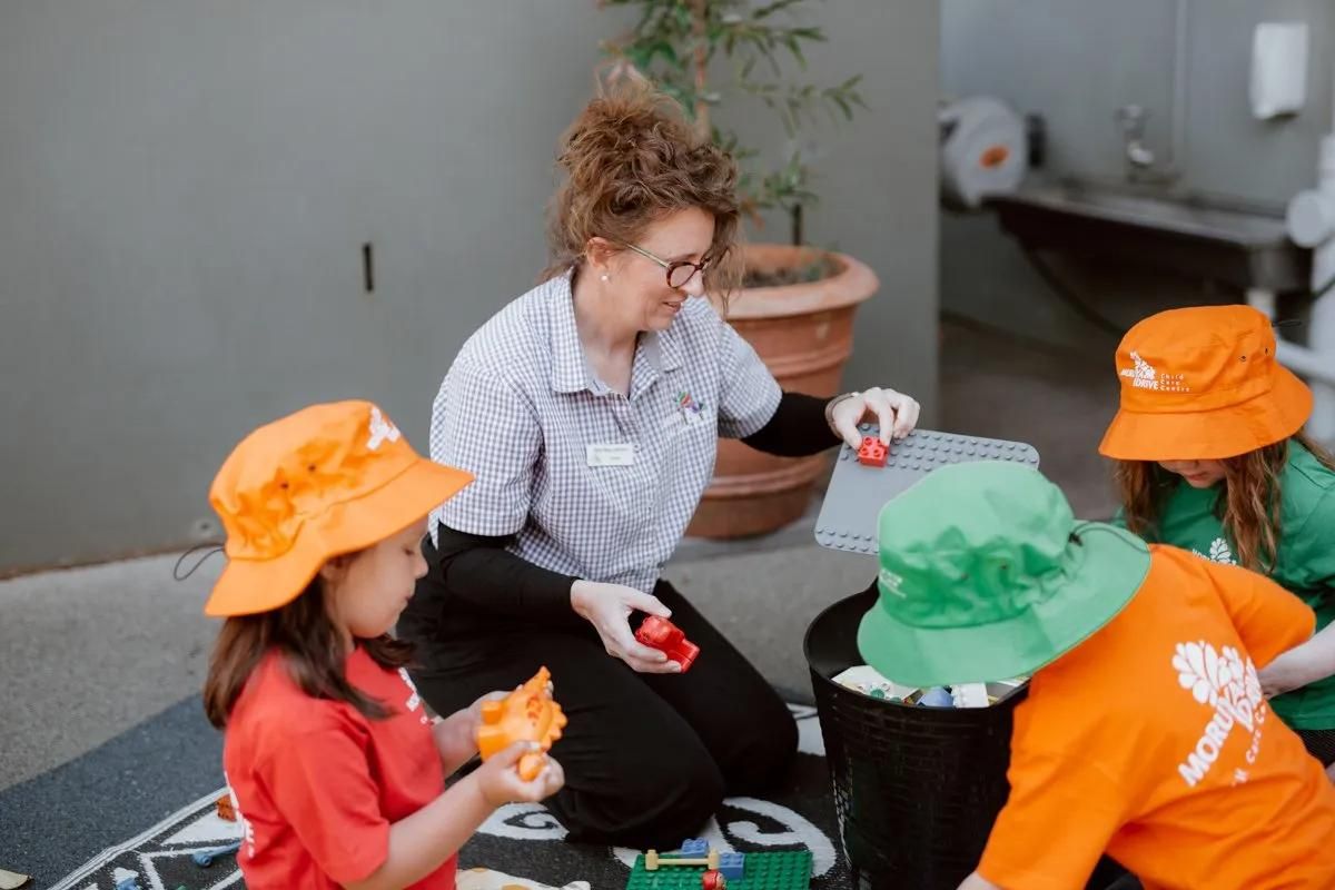 A Woman And A Child Are Playing With Toys In Front Of A Mirror — Moruya Drive Child Care Centre In Port Macquarie, NSW