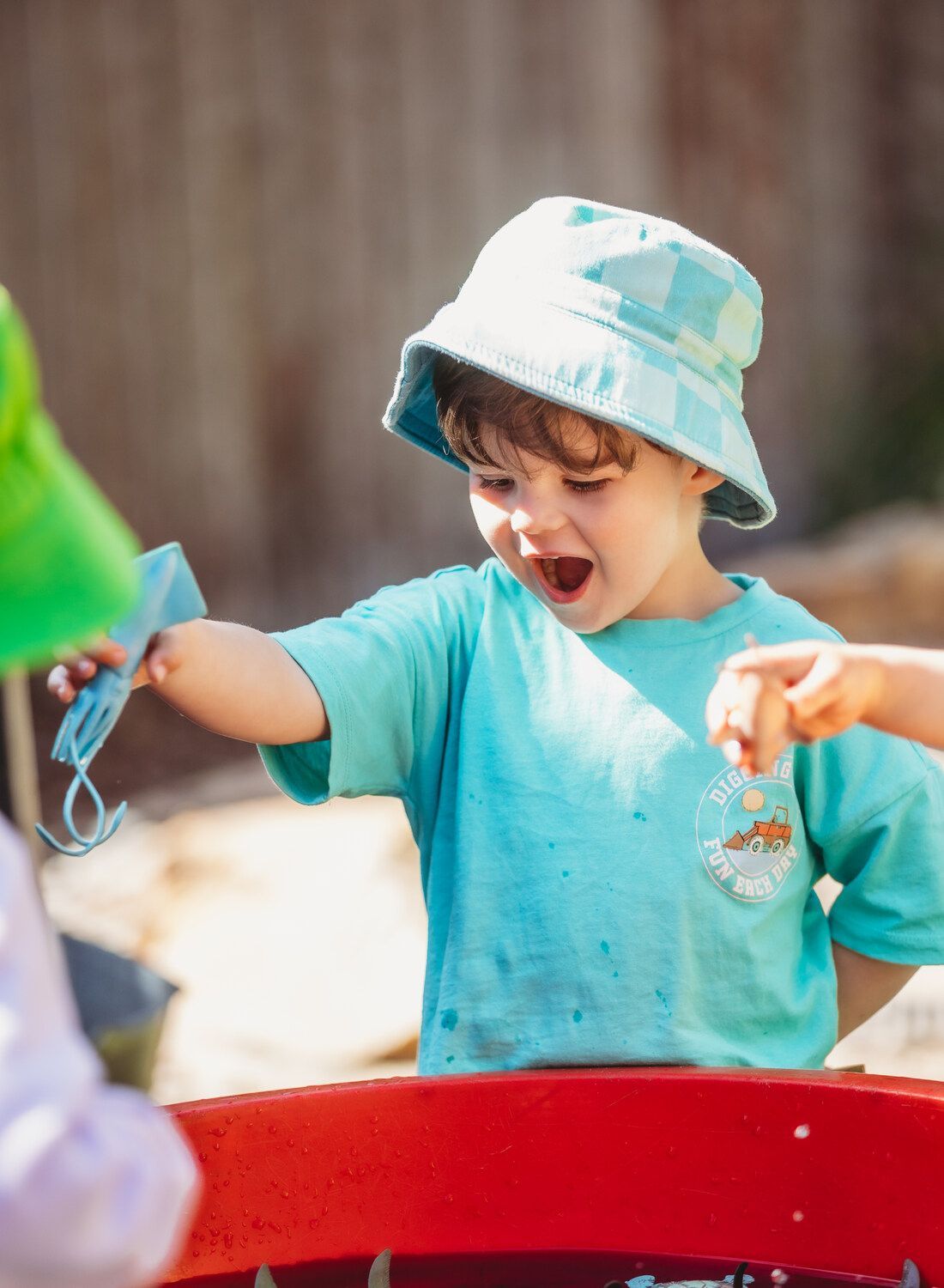 A little boy wearing a blue hat is playing in the sand — Moruya Drive Child Care Centre In Port Macquarie, NSW
