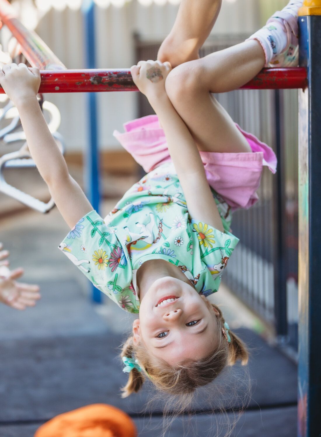 A young girl is hanging upside down on the playground — Moruya Drive Child Care Centre In Port Macquarie, NSW