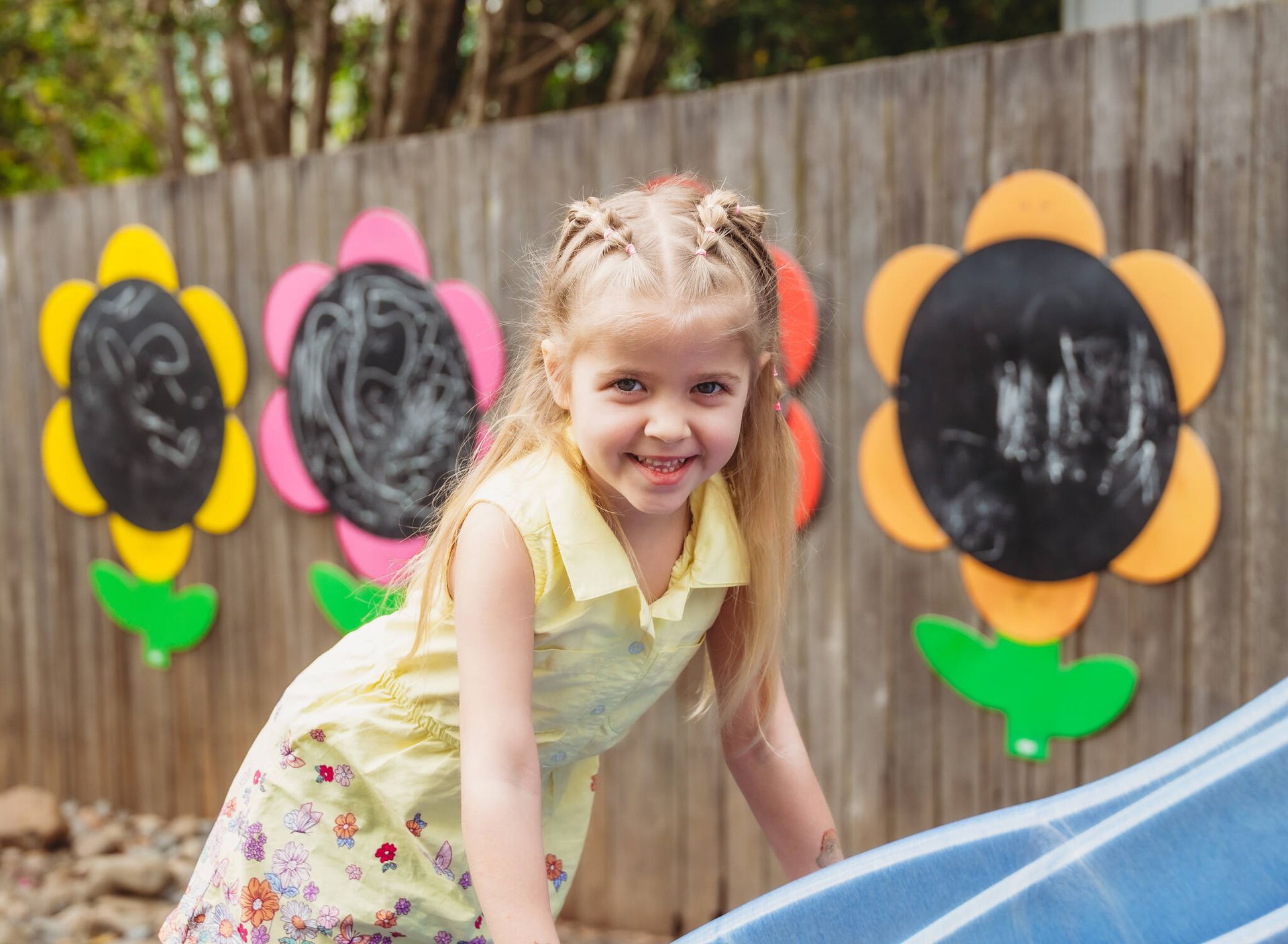 A little girl is playing on a slide in a playground — Moruya Drive Child Care Centre In Port Macquarie, NSW