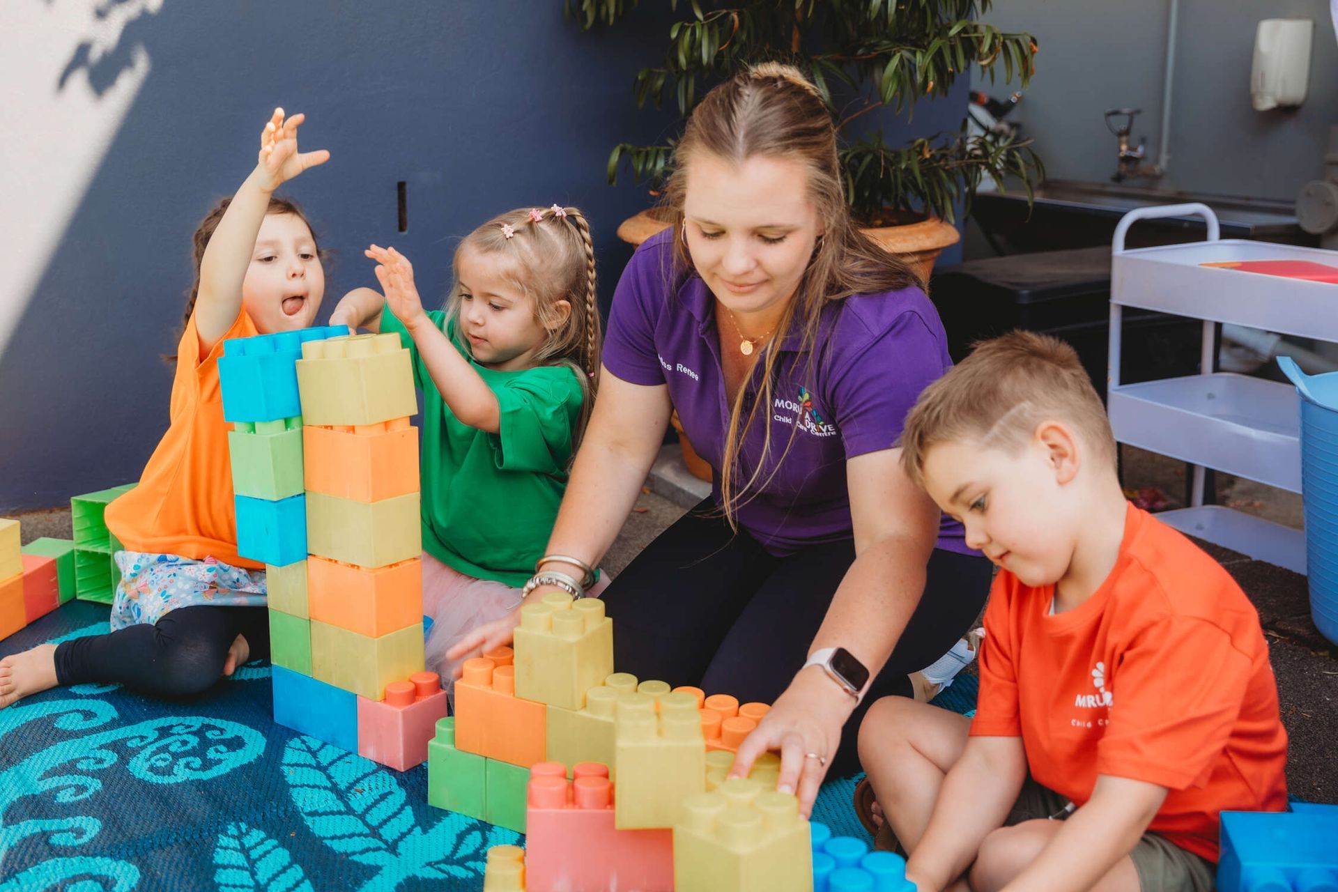 A group of children are playing with blocks on the floor — Moruya Drive Child Care Centre In Port Macquarie, NSW