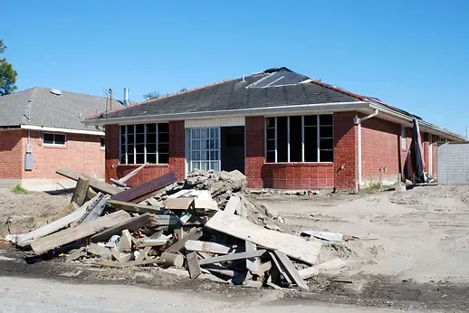 A brick house with a pile of rubble in front of it.
