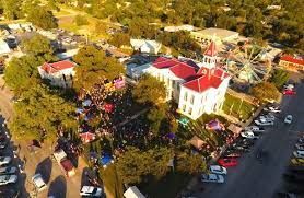 An aerial view of a city with a ferris wheel and a large building.
