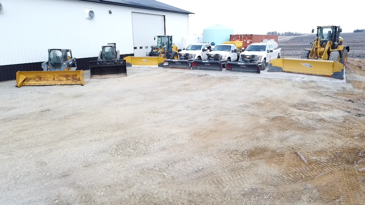 A row of tractors are parked in front of a building