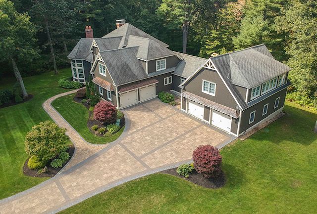 Wall-mounted radiant floor heating manifold with red PEX tubing, blue shutoff valves, and a green control box.