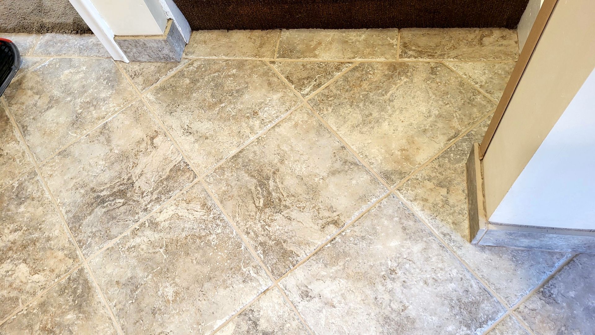 A person is standing on a tiled floor next to a door.