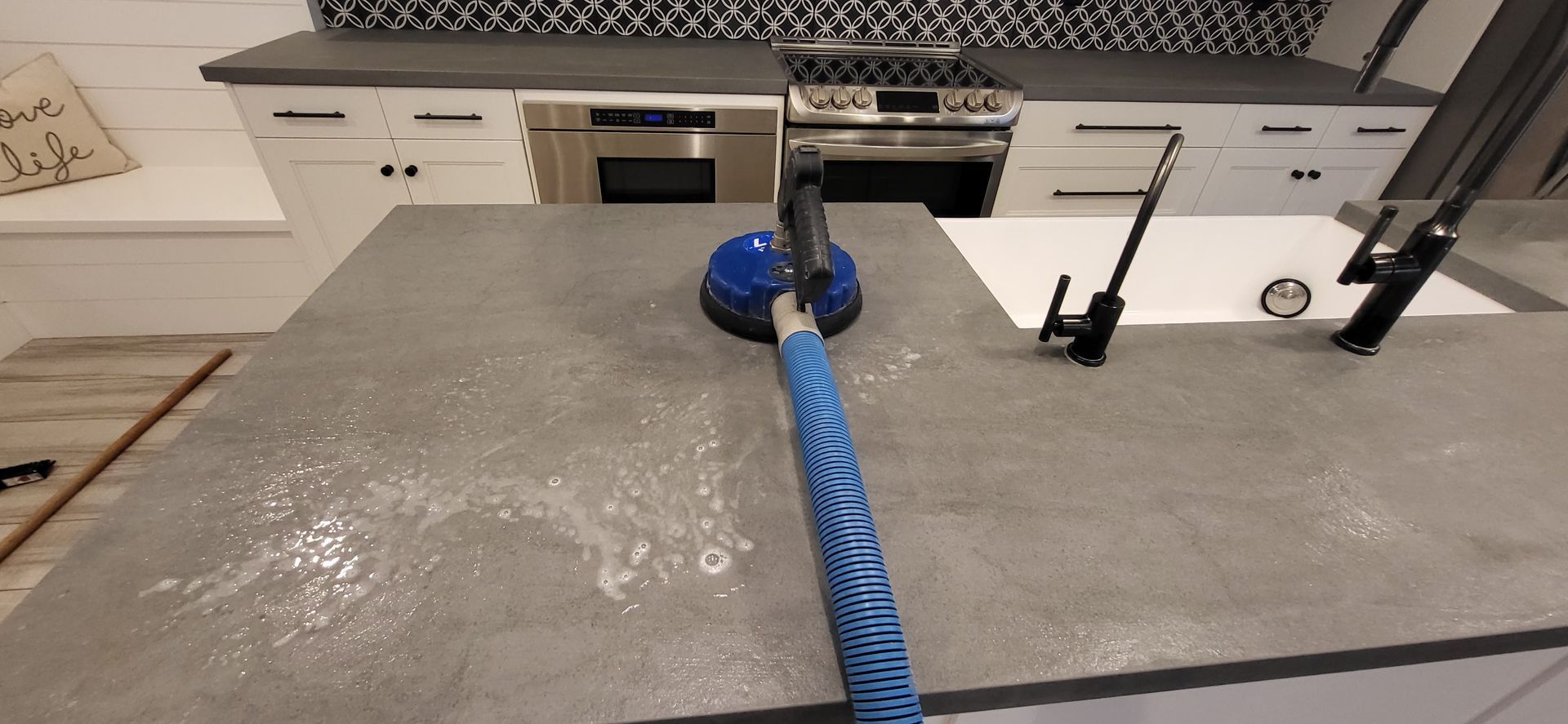 Cleaner wiping a cloth along grout lines between tiles to remove dirt and stains, revealing a cleaner and brighter surface.