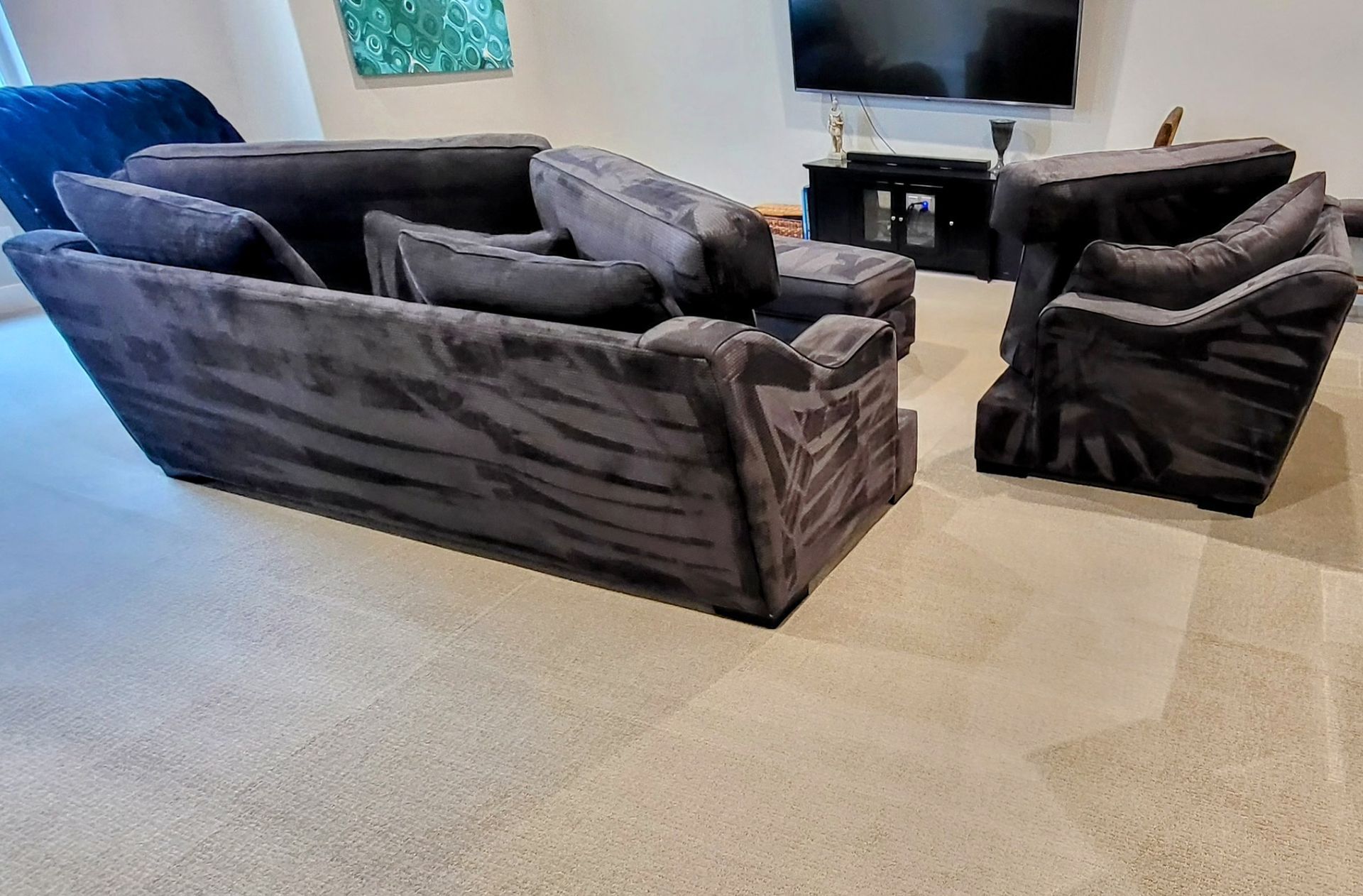 A person using a vacuum cleaner to meticulously clean an intricate rug with a pattern of vibrant colors and delicate designs.
