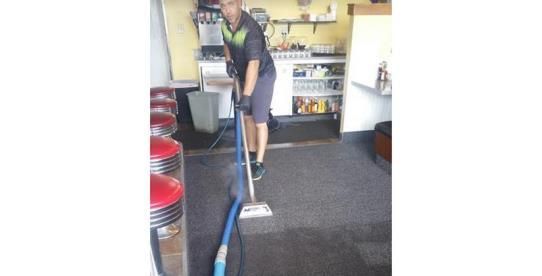 Efficiently cleaning a vibrant blue rug using a modern vacuum cleaner.