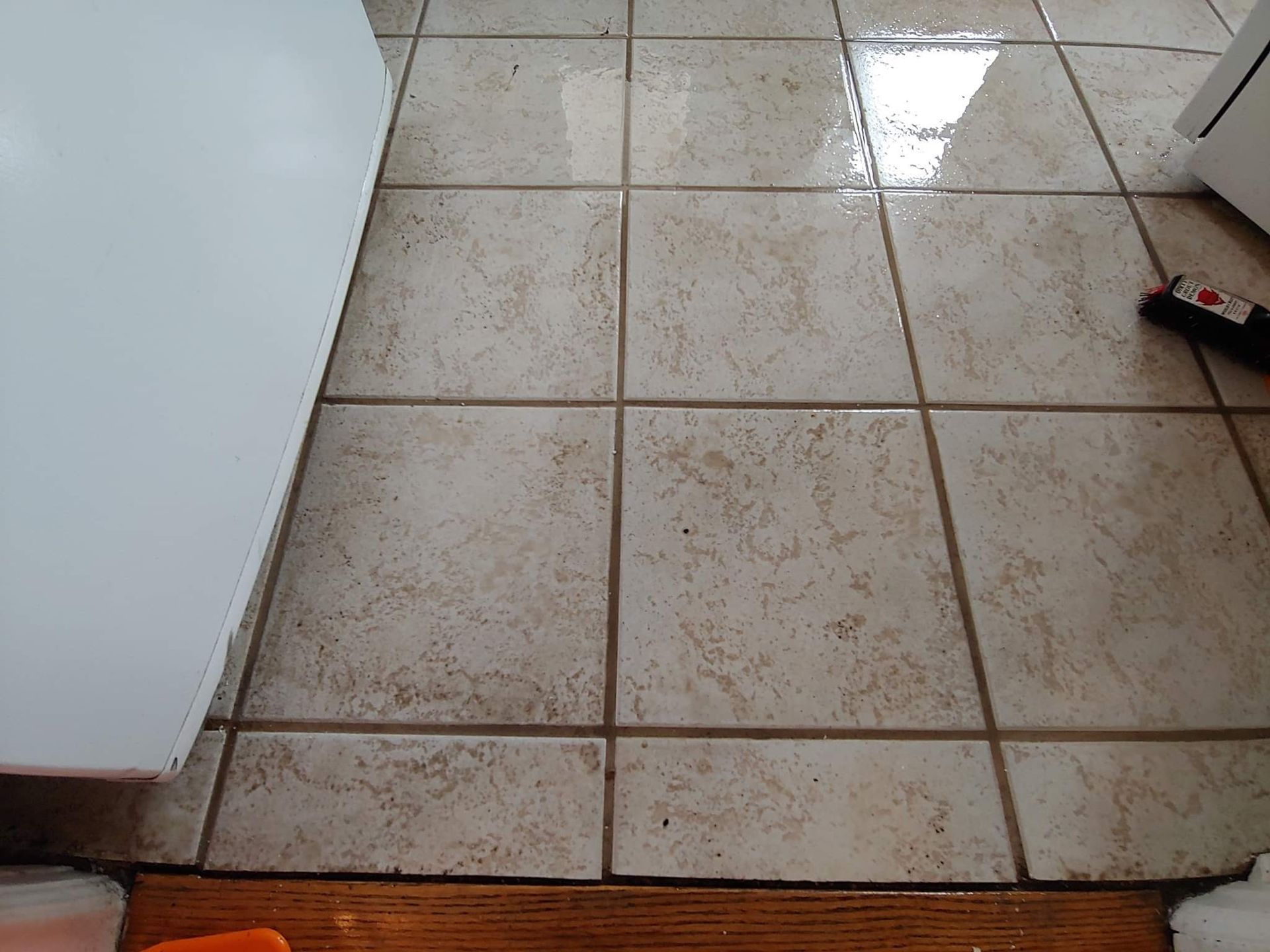 A tiled floor in a kitchen with a wooden floor