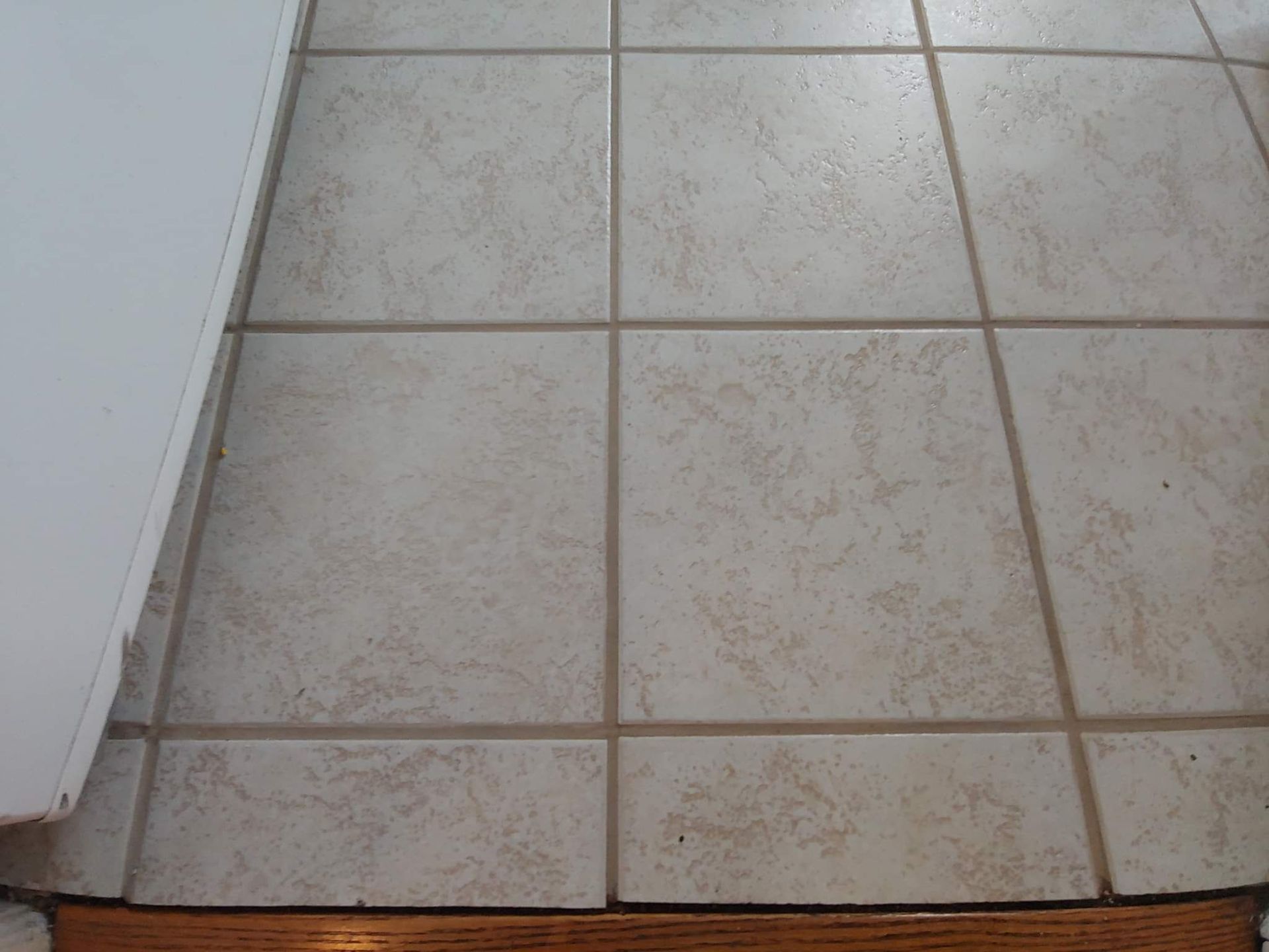 A close up of a tiled floor with a wooden border
