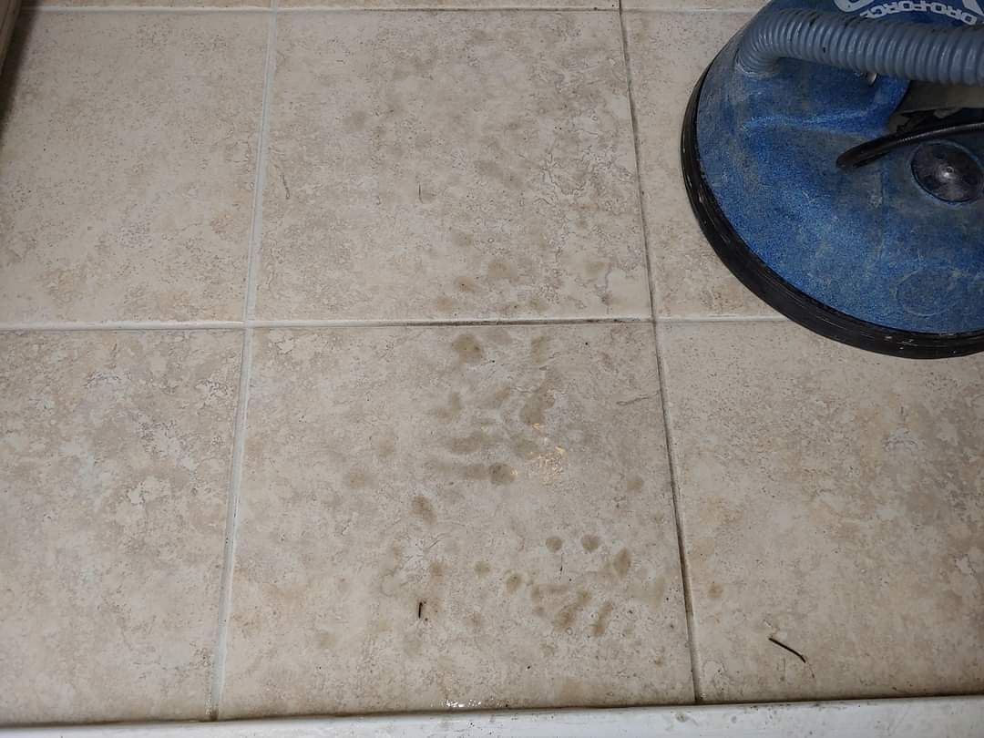 A tile floor with a vacuum cleaner on it.