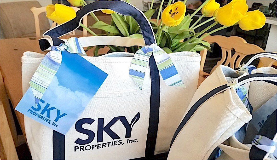 close up photo of a welcome gift pack showing a bag and card, top property management company