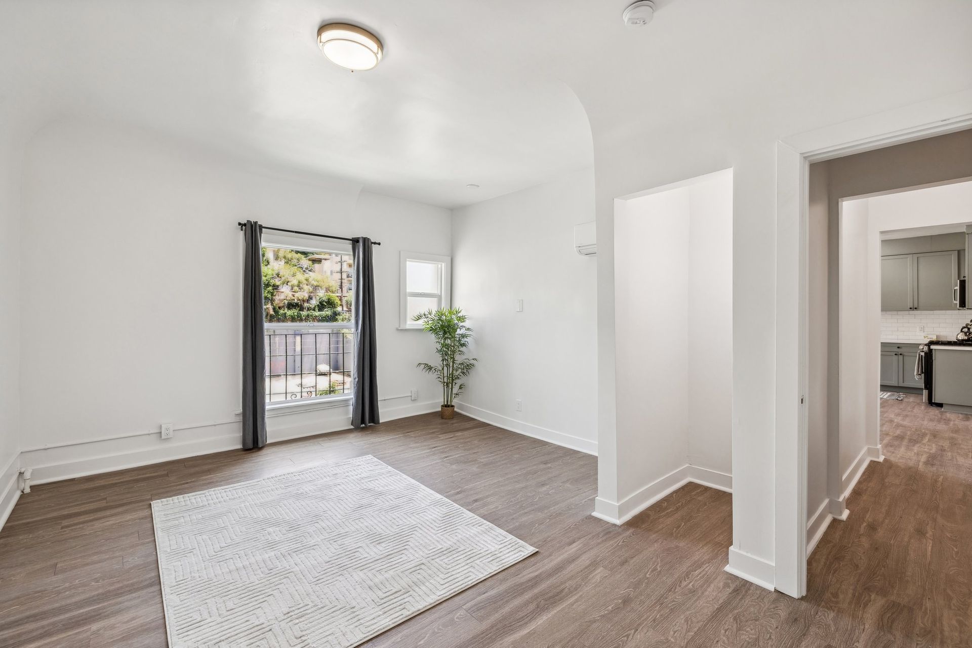 photo of a wider shot of the Ansley apartments' spacious and bright unit showing plank flooring and huge window