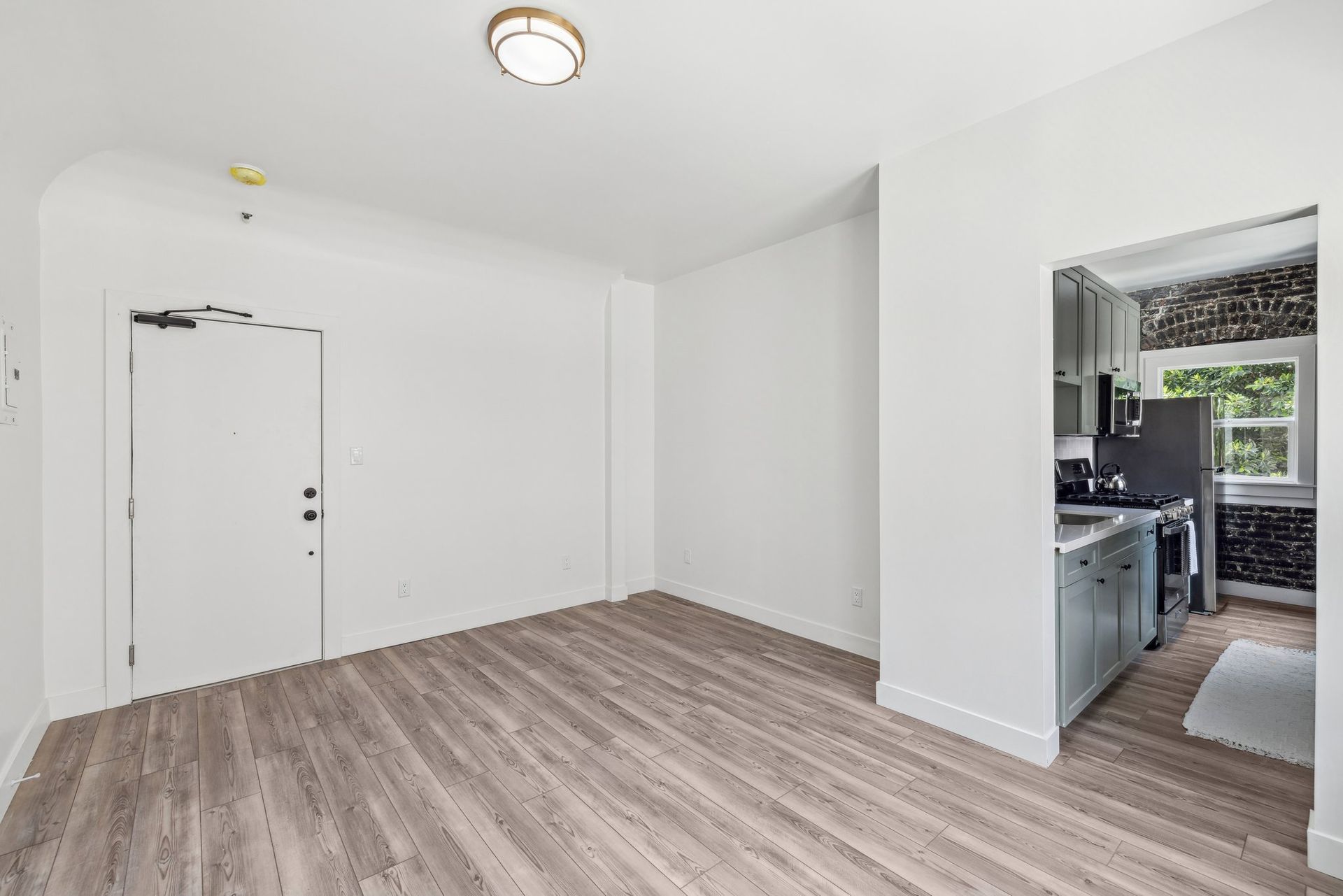 Interior photo of the Ansley Apartments, showing 2 huge windows with curtains and lots of natural light