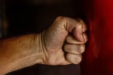 Clenched fist stomping on a wall respresents enforcing community rules for residents