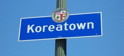 photo showing a blue metal signage of Koreatown LA attached to a street light column