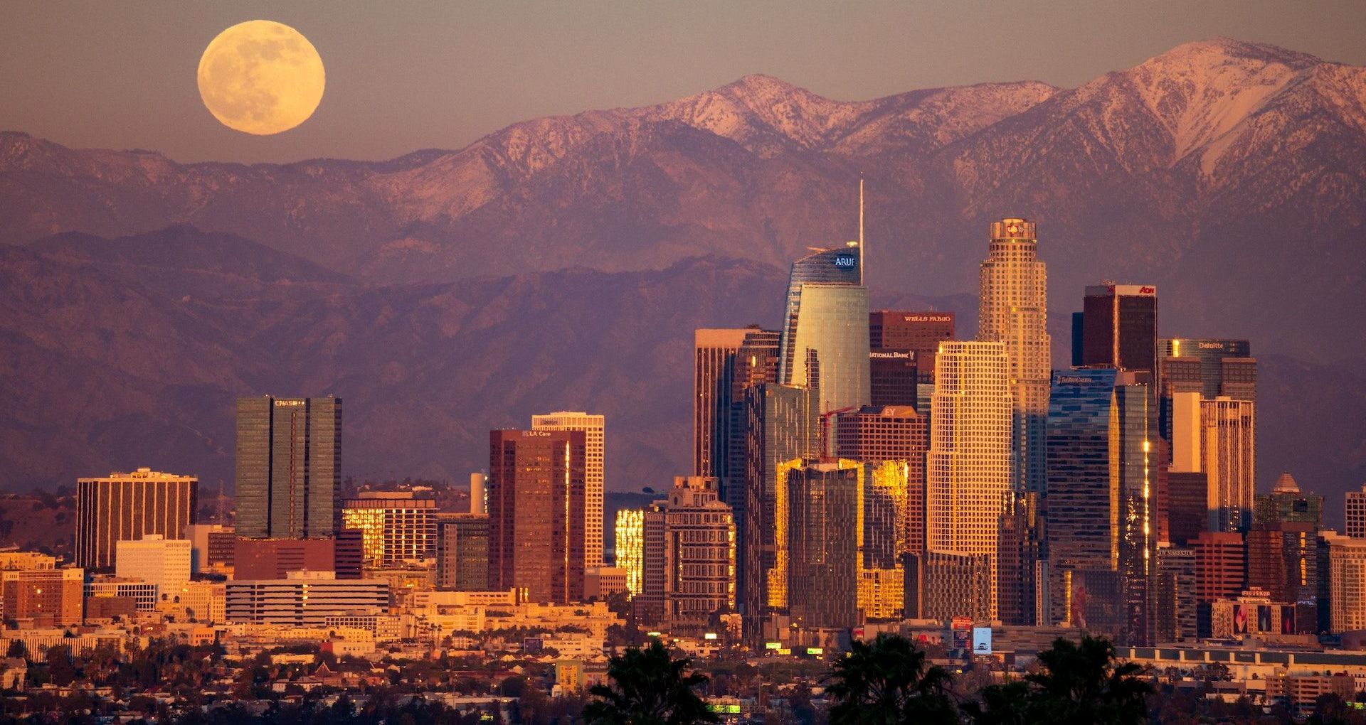 photo of the city skyline of Los Angeles against scenic mountain and moon background