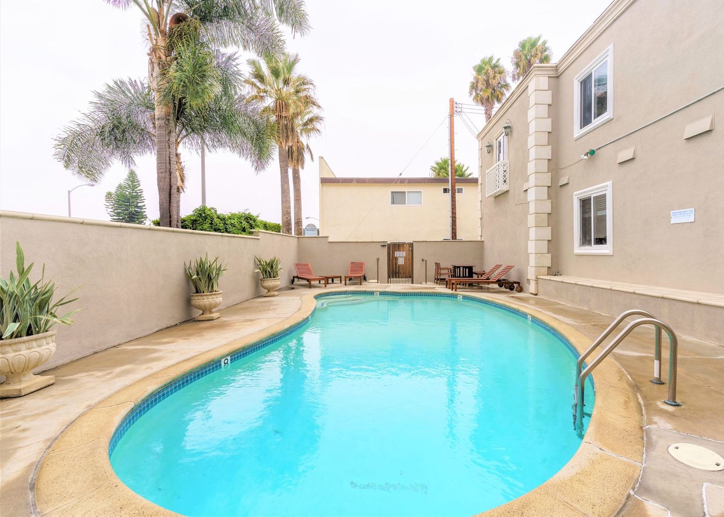 Large swimming pool with palm trees. Sky Properties Inc. - Leading Property Management Company in Toluca Lake