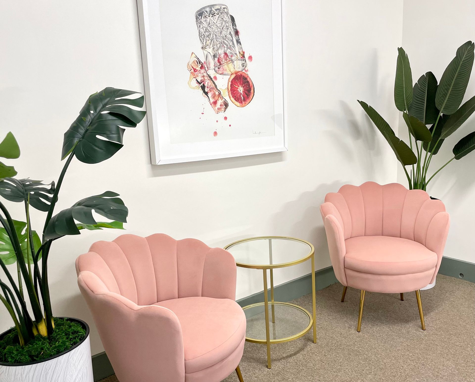 interior photo of the Ansley Apartments' reception area showing 2 couches and plants with a painting on the wall