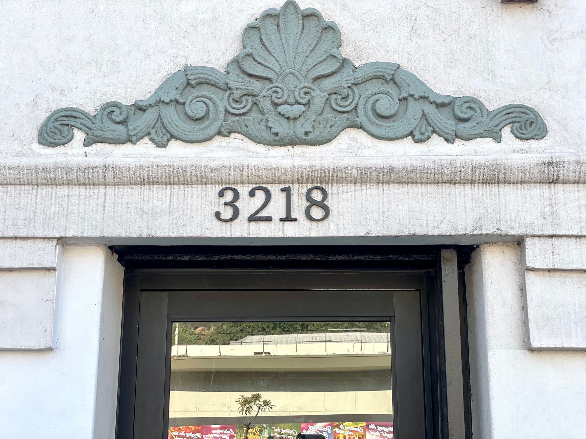 photo of the Ansley facade showing a close-up view of the building address and  a floral design accent above it