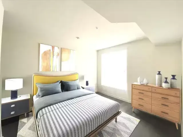 The Centennial Apartments spacious bedroom with vinyl plank flooring and huge windows that naturally brighten the room