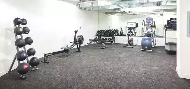 photo of The Centennial's fitness center showing a spacious carpeted gym with equipment