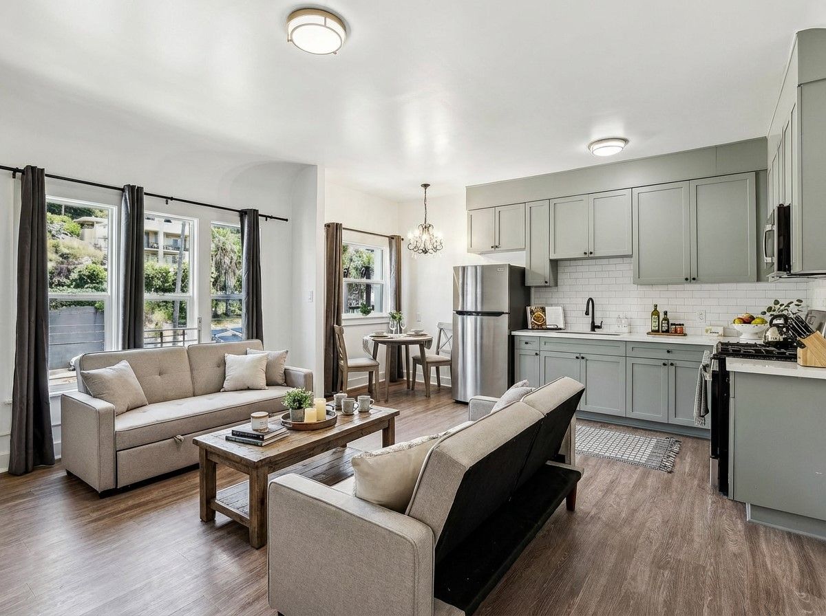 Room with exposed brick accent wall, windows, and wood-style flooring. At The Ansley, managed by SKY Properties, Inc.