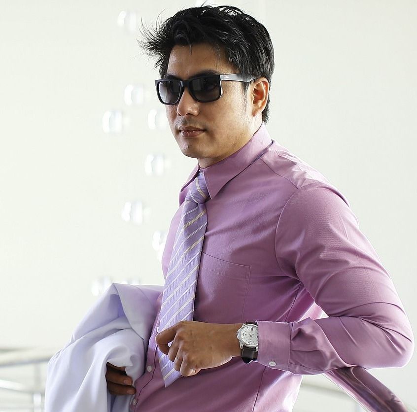close up view of a young business executive wearing sunglasses in light colored long sleeves and necktie