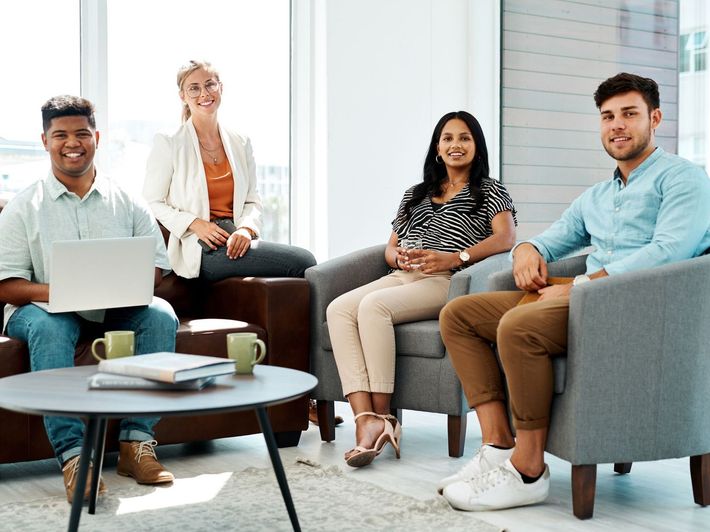 A group of professionals seated in chairs in a living room