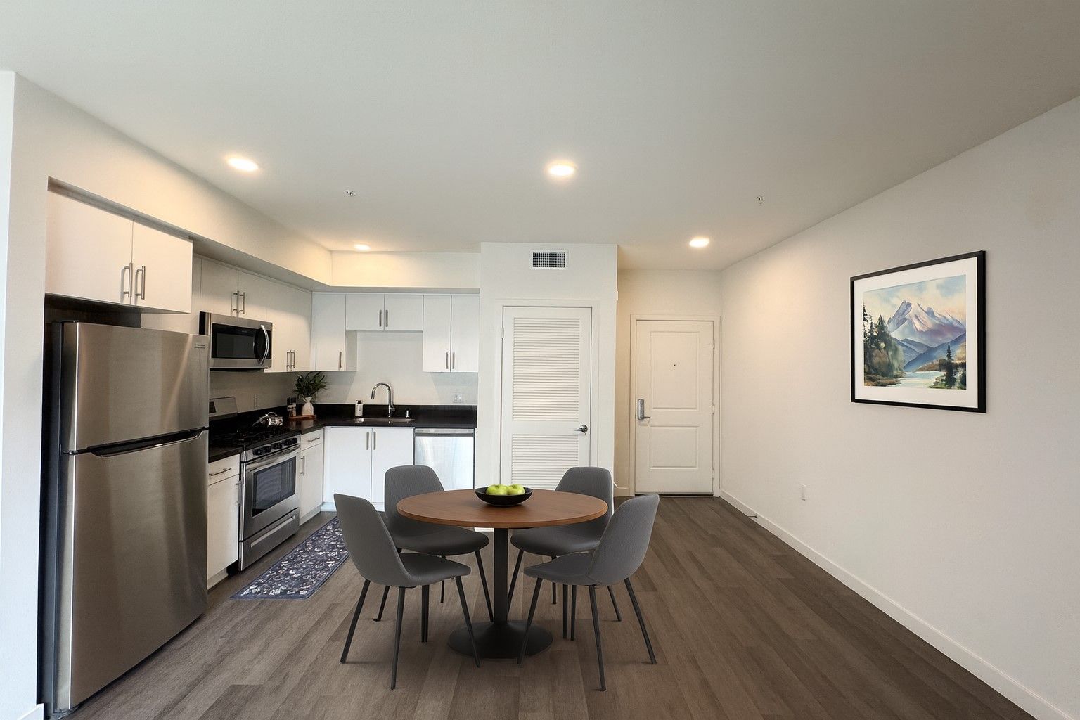photo of The Centennial's cozy and bright bedroom with a bed, side table and windows with opened blinds
