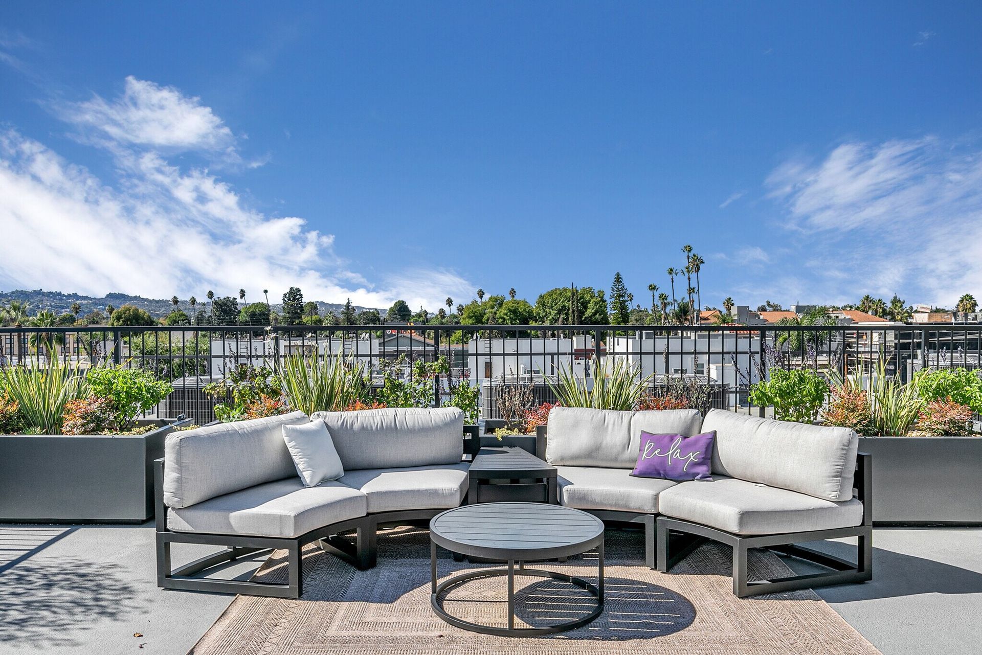 Photo showing an the Mix Luxury Apartment rooftop showing the outdoor barbecue, roof top tables and lovely plants