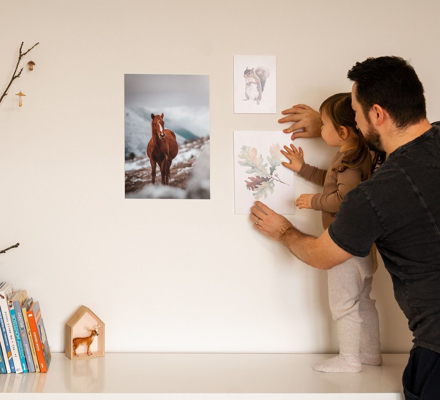 image of a couple setting a picture frame on a wall inside an apartment