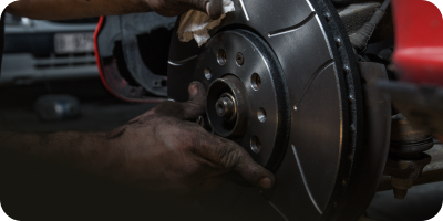 A person is fixing a brake disc on a car. | Oceanside Tire and Service Center Tire Pros