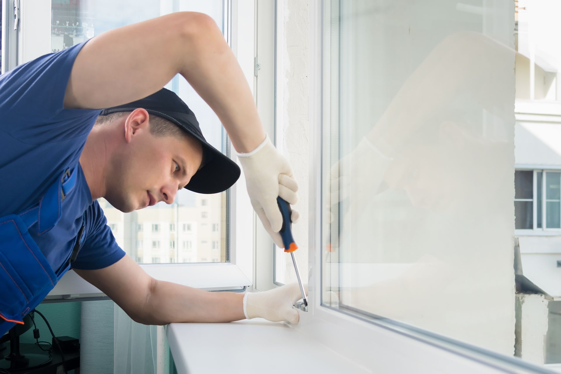 A technician installing a window in an office setting.