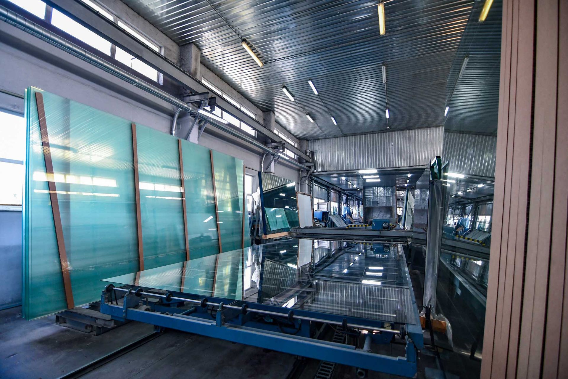Large glass panels on a factory production line, under metallic ceiling. Large glass panels on a factory production line, under metallic ceiling.