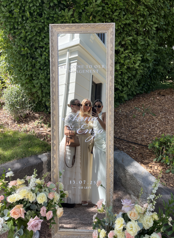 Une longue table avec des assiettes, des verres et des serviettes dessus.
