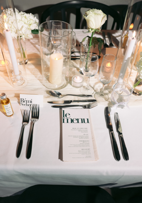 Un numéro de table dans un cadre doré se trouve sur une table avec des fleurs.