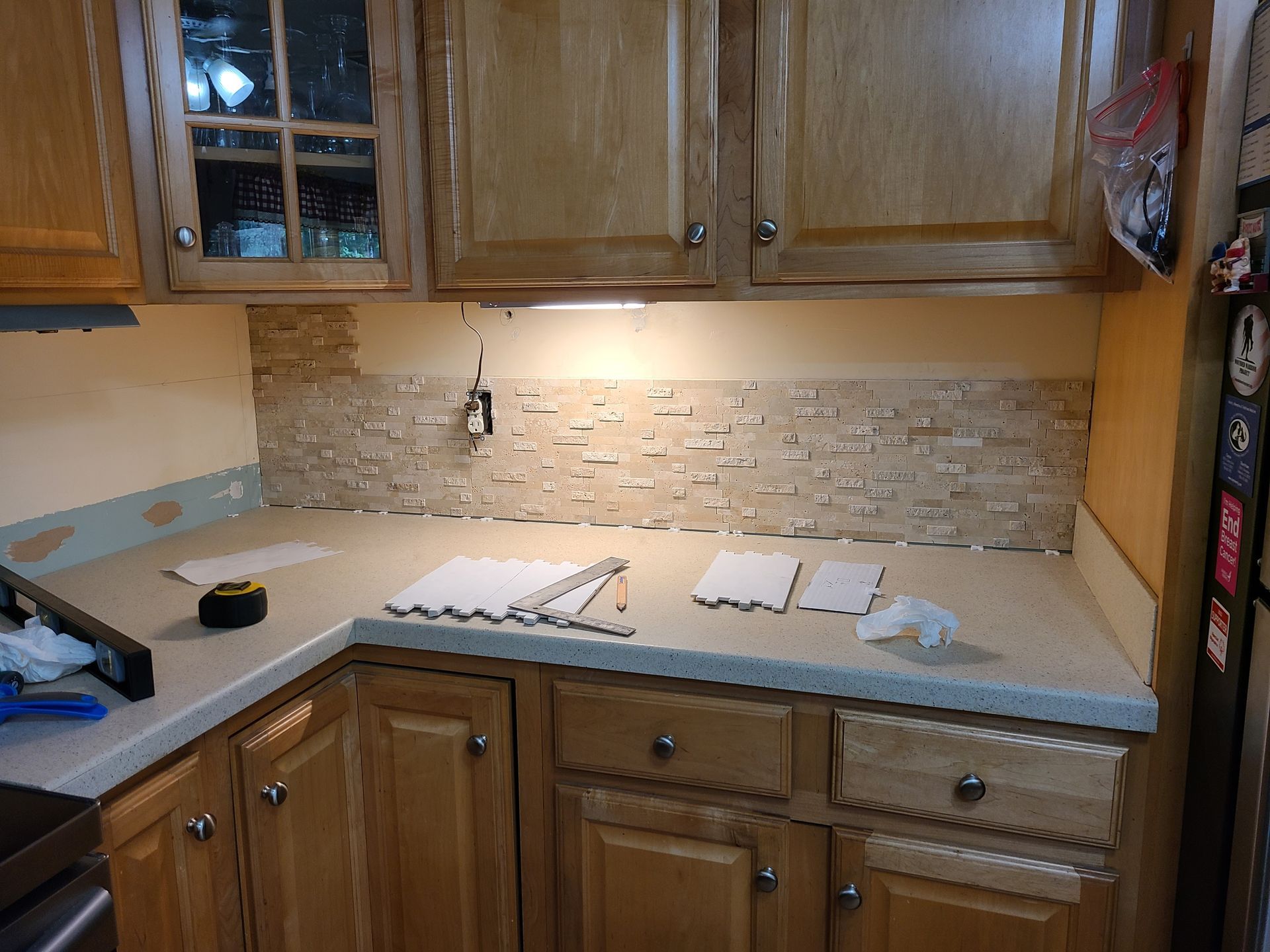 Modern kitchen with white cabinets, navy island, stainless steel appliances, and hardwood floors.