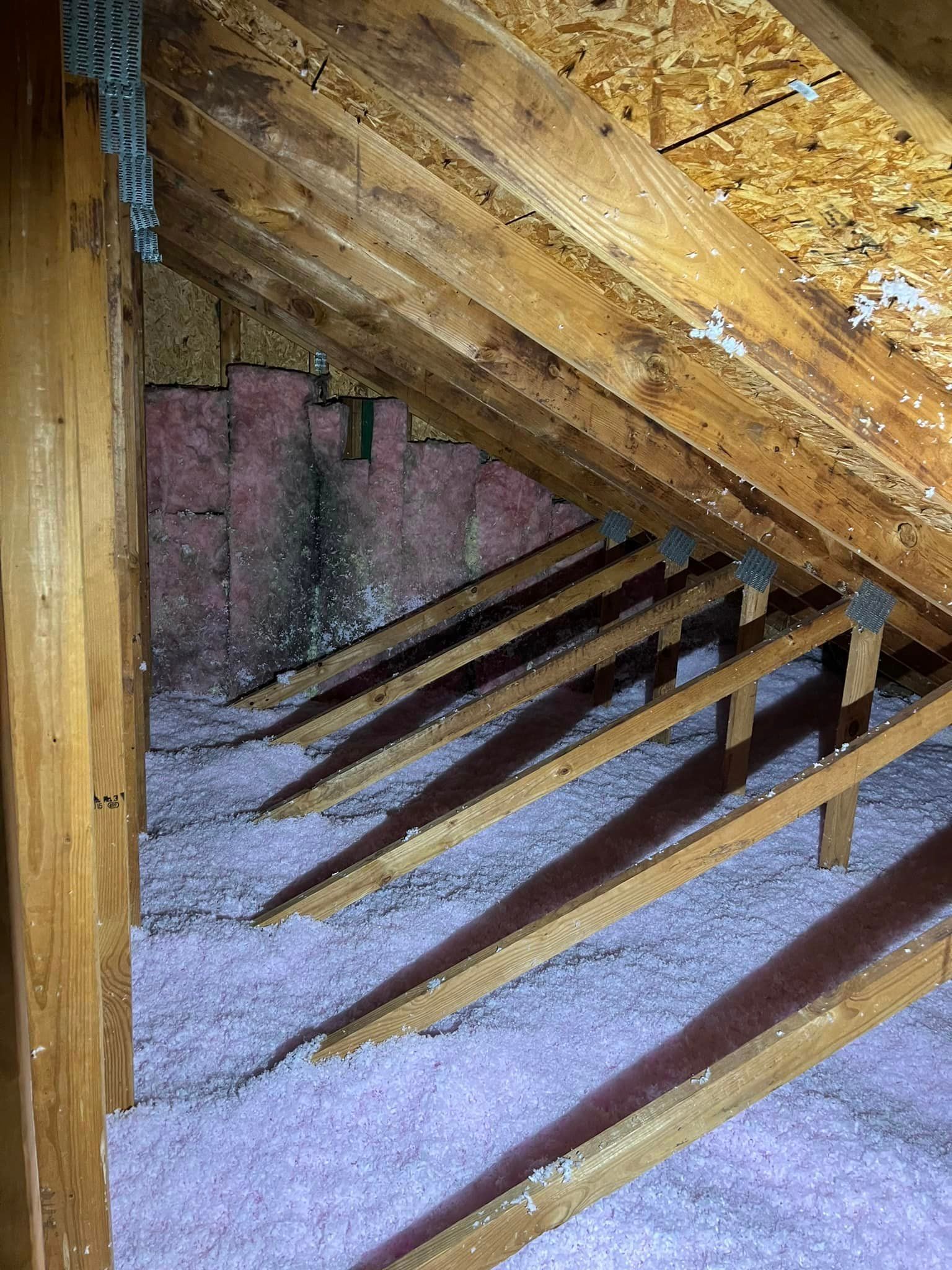 There is a lot of insulation in the attic of a house.
