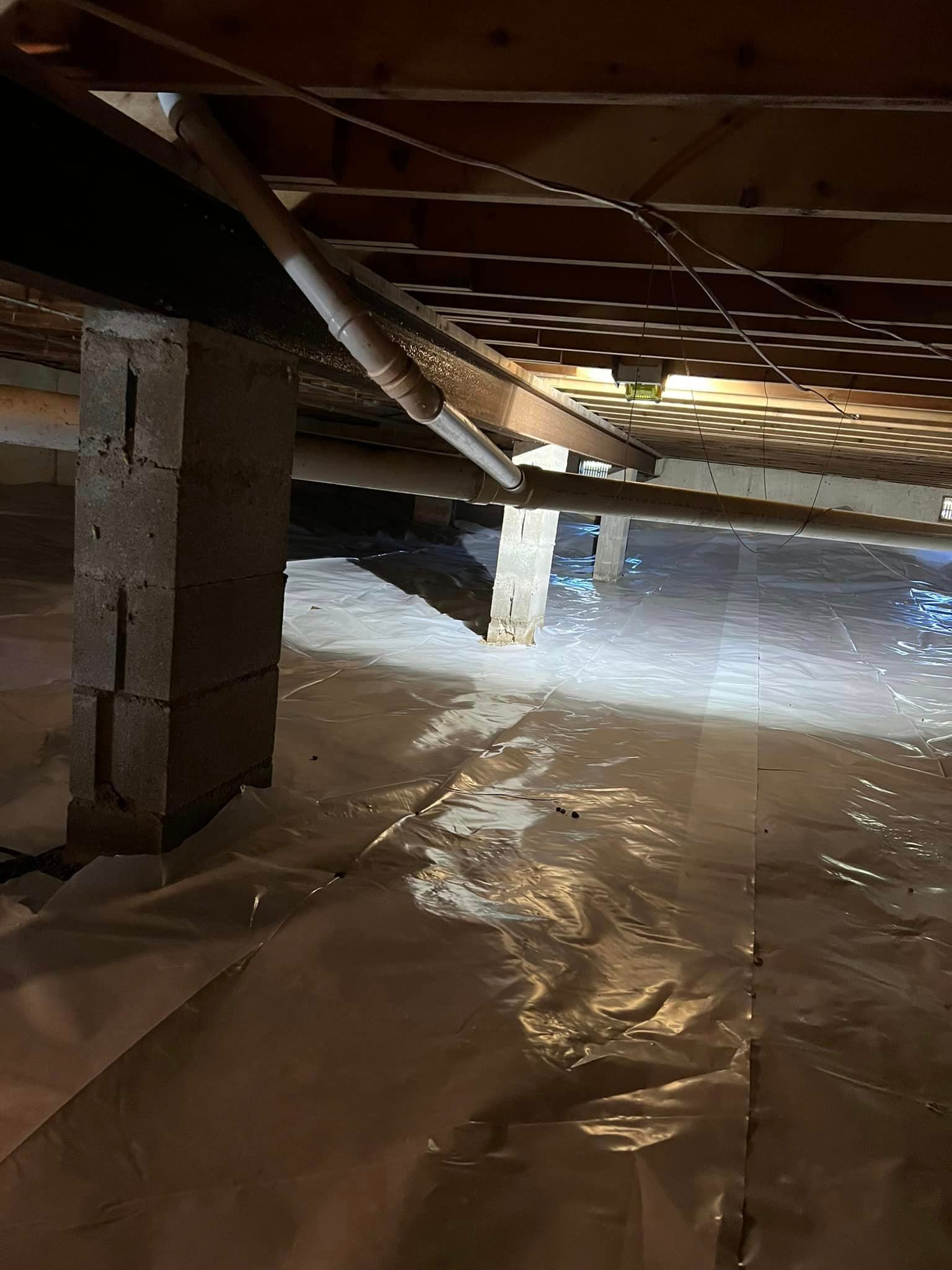 The bottom of a basement with a lot of plastic covering it.